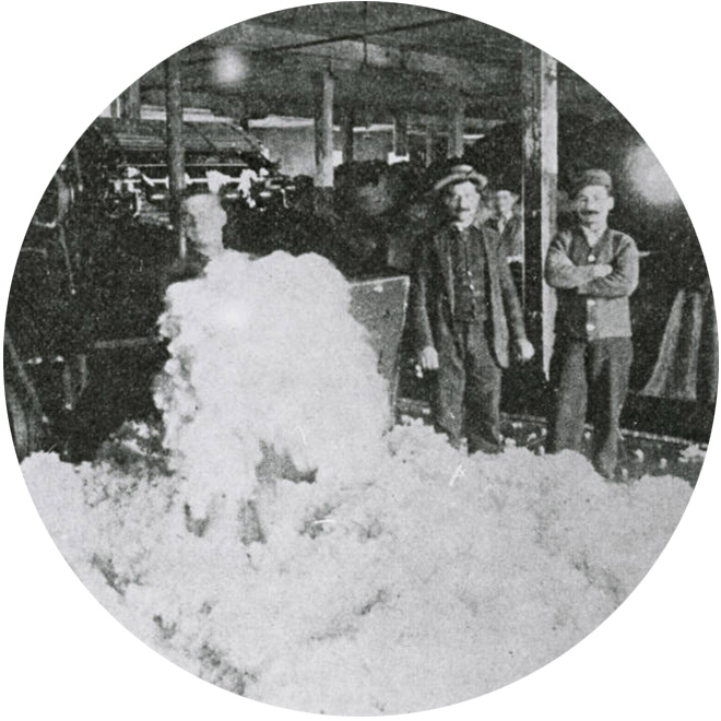 Historical photo of men with piles of raw wool at Provo Woolen Mills